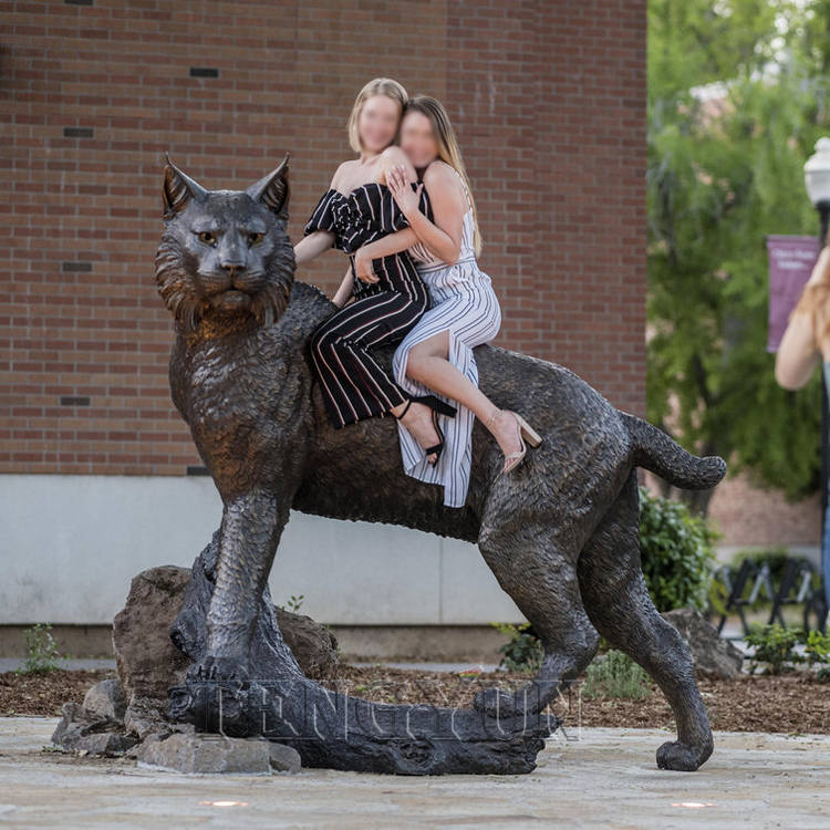 Taylor Sartori (PSYC major, age 22, from Grass Valley) (left) and Morgan Callison (CHLD major, age 21, from Grass Valley) (right) hop onto the Wildcat Statue, designed by Washington-based artist Matthew Gray Parker, the seven-foot-long, 1,500-pound bronze statue is a replication of the native bobcat (Lynx rufus californicus), which the student body declared as the University’s mascot in 1924, seen in Wildcat Plaza on Sunday, April 22, 2018 in Chico, Calif. (Jason Halley/University Photographer/CSU Chico)